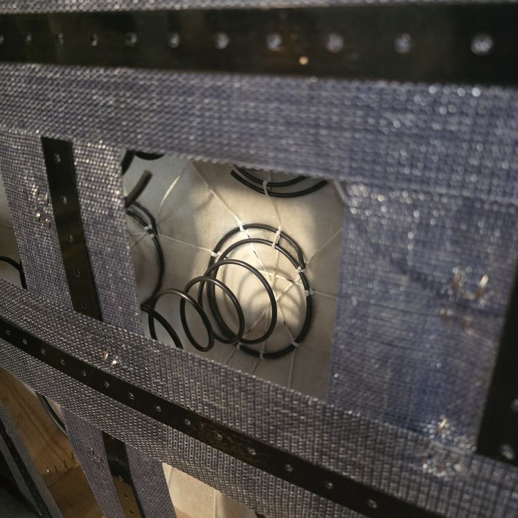 Underside of Chesterfield sofa showing hand-tied coil springs and webbing
